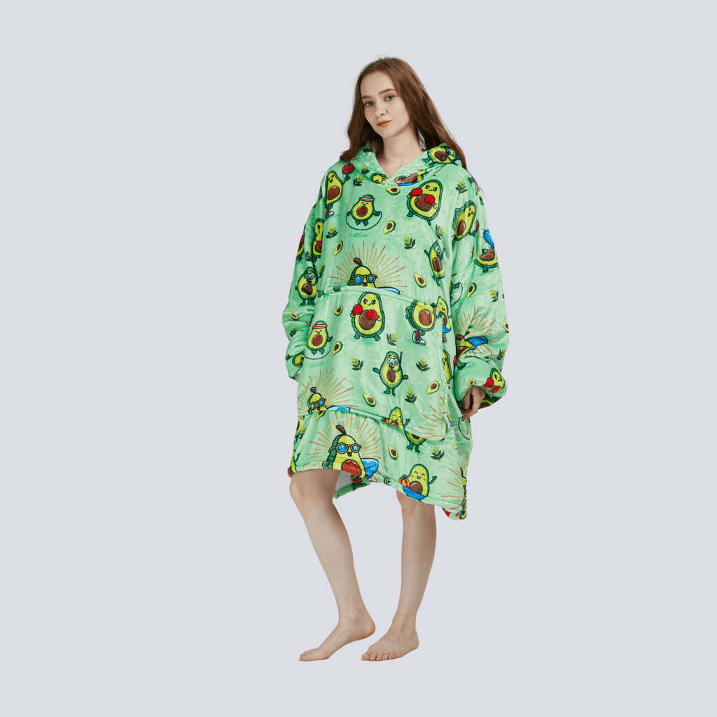 Adult wearing the Avocado Wrap hoodie blanket, standing with one arm relaxed at the side, showing oversized cozy fit.