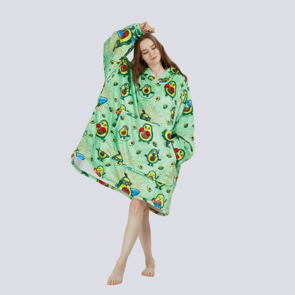 Fun playful pose of adult model wearing the Avocado Wrap hoodie blanket, showing relaxed oversized fit.