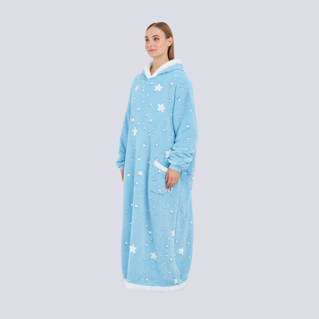 Female model standing in oversized baby blue hoodie blanket with star print, full body view