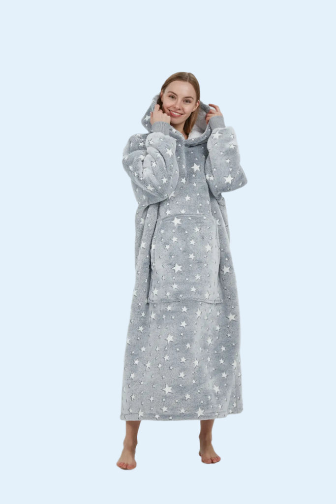 Full-length front view of oversized grey star hoodie blanket worn by model standing barefoot.