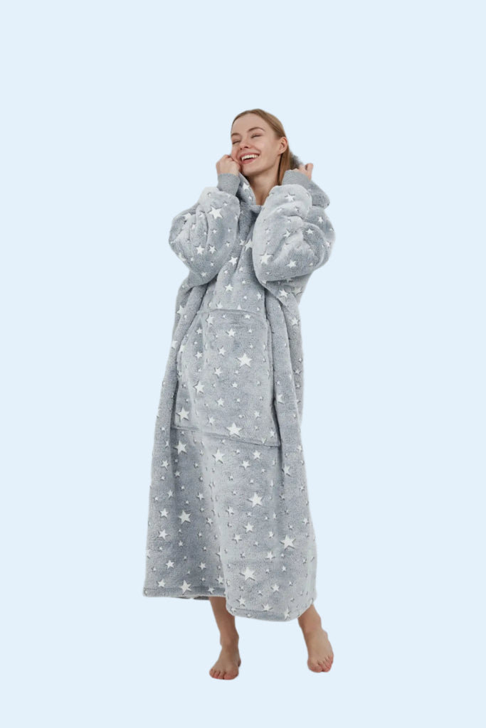 Model laughing joyfully in a grey star hoodie blanket, creating a warm and inviting lifestyle moment.